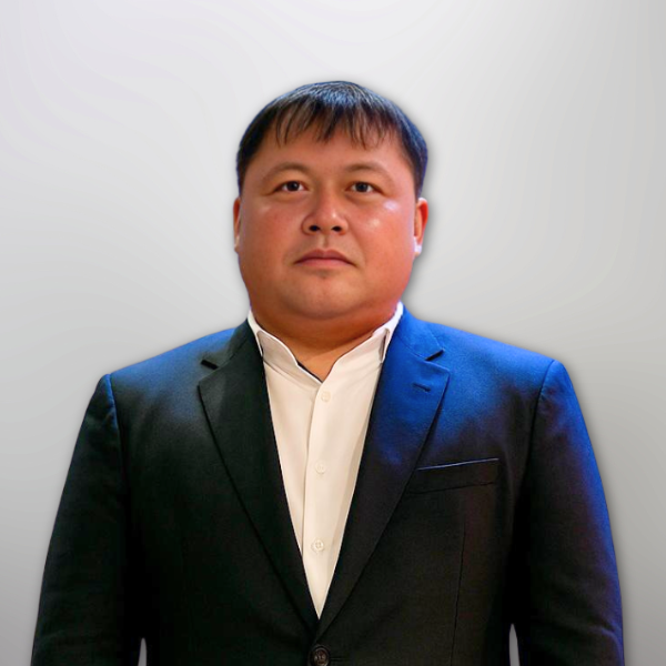 Foto resmi Ps Tony Ajengwan, perwakilan Biro Penginjilan Majelis Daerah GPdI Australia, mengenakan jas formal berwarna hitam pekat dengan kemeja putih berkerah tegak tanpa dasi. Ps Tony tampil dengan gaya rambut pendek rapi, wajah bulat, dan ekspresi serius namun bersahabat. Latar belakang gambar menggunakan efek gradien abu-abu terang dengan pencahayaan lembut, menciptakan kesan profesional. Gambar ini digunakan untuk keperluan identitas struktur organisasi GPdI Australia, khususnya sebagai profil pelayanan di bidang penginjilan.